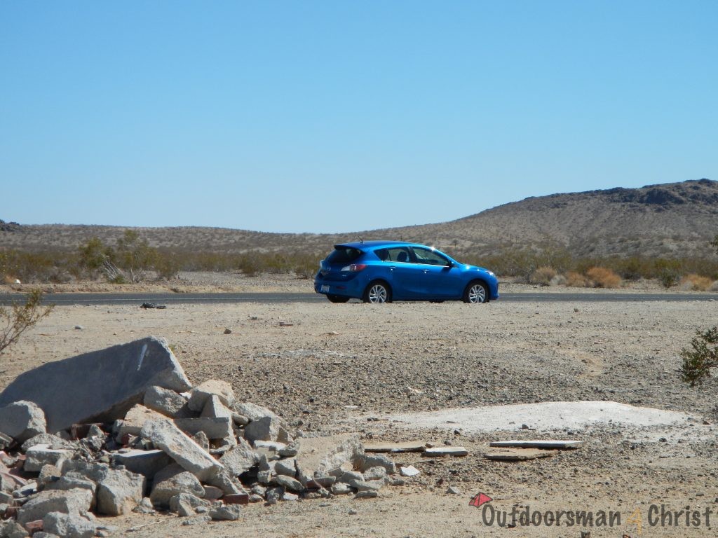 My car off in the distance from the dilapidated building